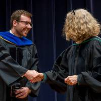 Faculty member shaking Provost Drake's hand